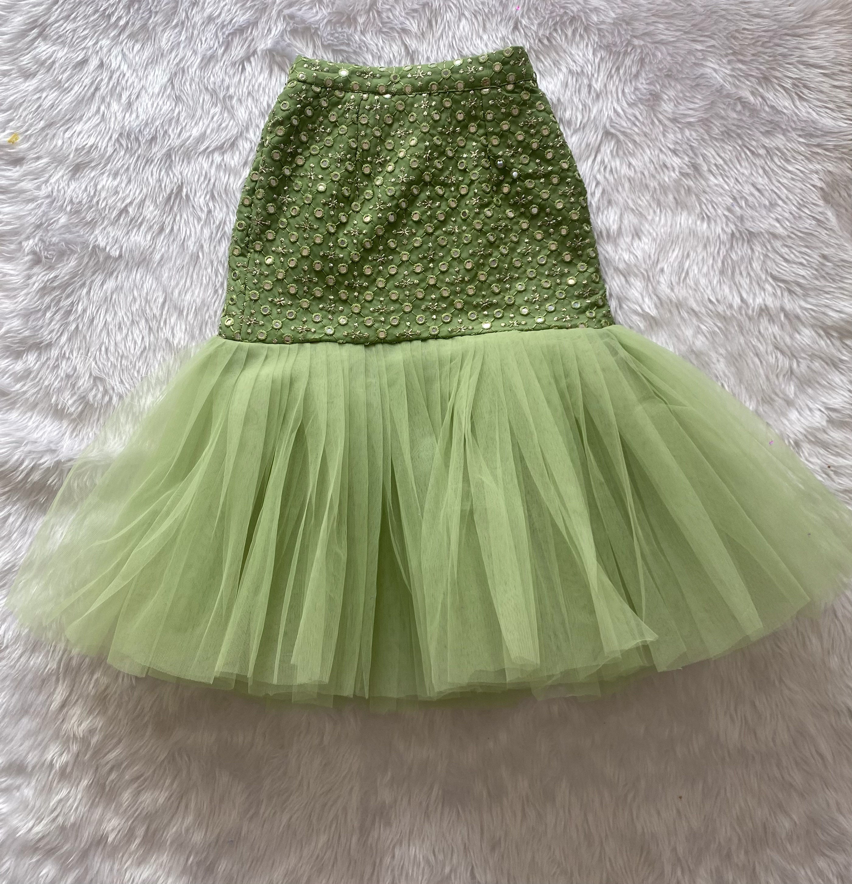 Green sequin top and tulle skirt set on a fluffy gray surface